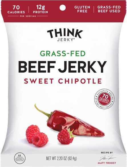 Chef-crafted grass-fed beef jerky displayed on a rustic wooden table, highlighting its gourmet packaging.