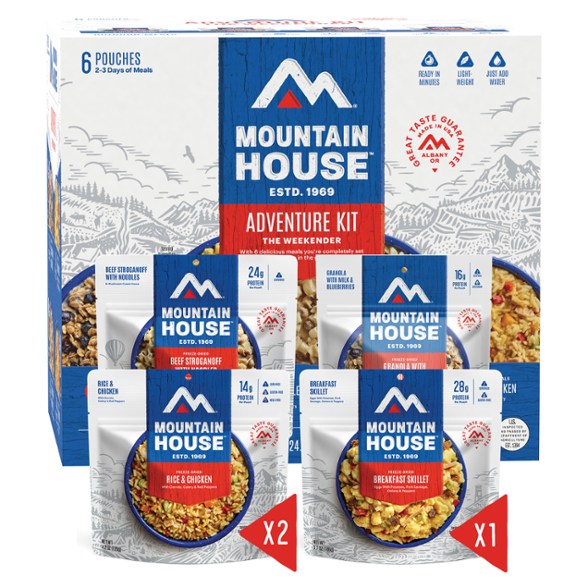 Mountain House Adventure Survival Kit displayed outdoors, showcasing dehydrated meals in pouches.