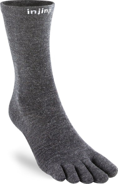 Close-up of Injinji Merino Wool Toe Crew Hiking Socks on a hiker's feet on a mountain trail.