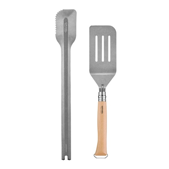 Top-down view of the Opinel TrailMate grilling set arranged on a rustic wooden surface—knife, spatula insert, and tongs laid out
