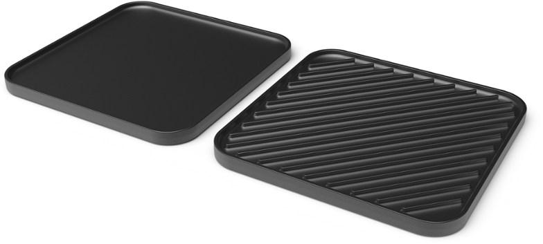 Close-up of cast iron griddle and camping grill combo on Cascade stove showcasing versatile cooking options