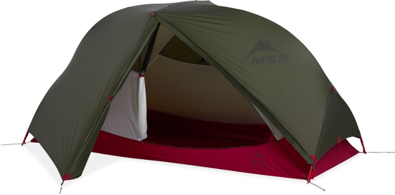 MSR Hubba Hubba Bikepack tent set up at a campsite with cycling gear stored in the vestibule.