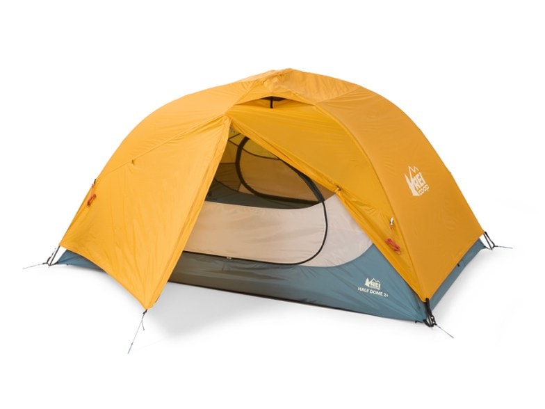 Exterior view of the Adventure Ready Half Dome 2 Plus tent set up in a forest with its rainfly on.