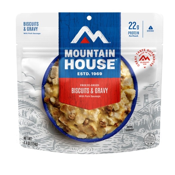 Mountain House Biscuits & Gravy meal prepared in a camping setting with a scenic background.