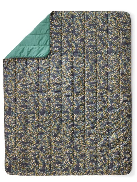 Adventure Ready camp blanket spread out by a campfire, showcasing its vibrant colors and durability.