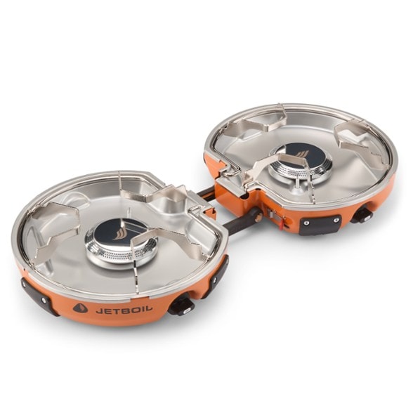 Side view of Jetboil Genesis dual burner camping stove setup at basecamp with fuel regulator attached