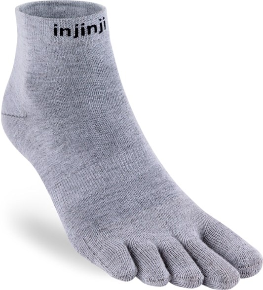 Injinji toe socks displayed on a rock in nature, showcasing their mini crew height and moisture-wicking fabric.
