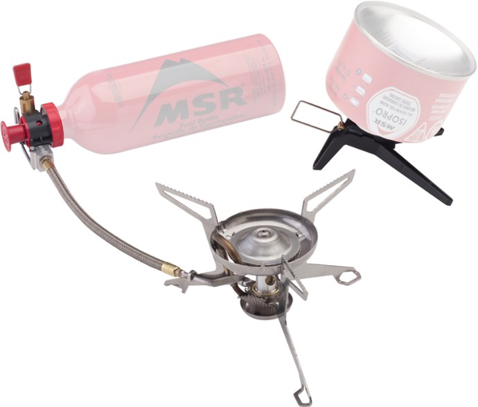 Angled shot of MSR WhisperLite Expedition Stove setup on rocky terrain with fuel pump attached