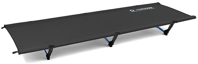 Helinox Cot One Deluxe setup by the campfire, showcasing its sturdy design for outdoor sleeping.