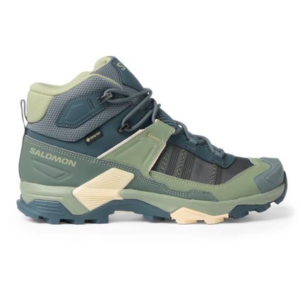 Side view of TrailBlazer Women's GORE-TEX Mid Hiking Boots on rocky terrain.