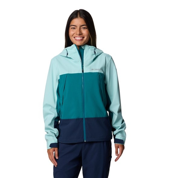 Woman wearing the Eco-Friendly Boulder Falls jacket while hiking in the rain, showcasing its stylish design.