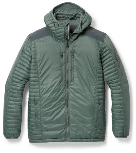 Front view of men's Kühl down jacket worn in snowy alpine setting, hood up for maximum warmth.