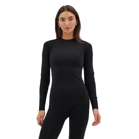 Eco-Active Women's Base Layer Top in action during skiing, showcasing its stylish mock neck and moisture-wicking features.