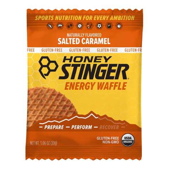 Honey Stinger gluten-free waffles displayed on a wooden plate, showcasing their delicious honey filling.