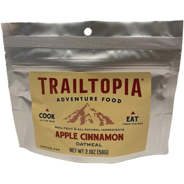 Close-up of Trailtopia Apple Cinnamon Oatmeal bag with a bowl of prepared oatmeal in the background.