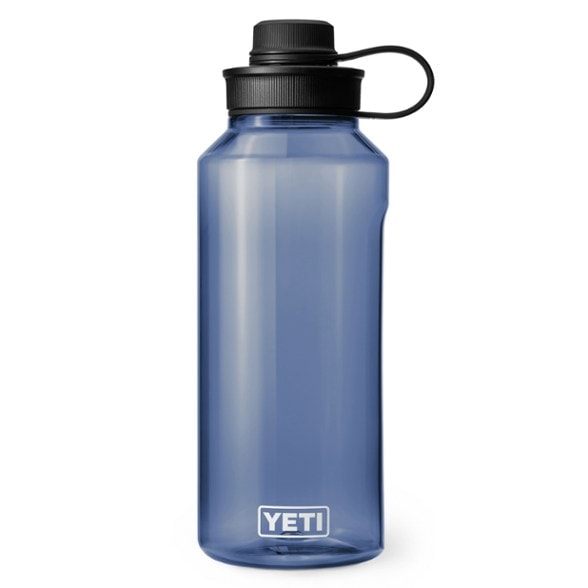 Side view of YETI Yonder 50 oz water bottle with tether cap on a rocky trail.
