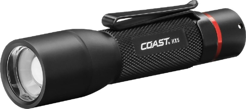 Coast HX5 rechargeable flashlight with clip shown outdoors during camping.