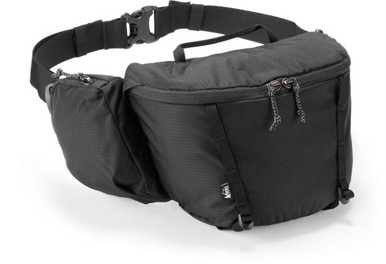 Side view of the waist pack showing stretch water bottle pocket and angled compression straps