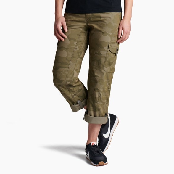 KÜHL women's adventure roll-up pants displayed on a hiking trail with a scenic backdrop.