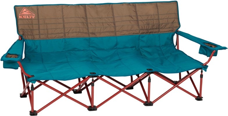 Front angle of TrailNest camp couch positioned near a campfire with three people lounging