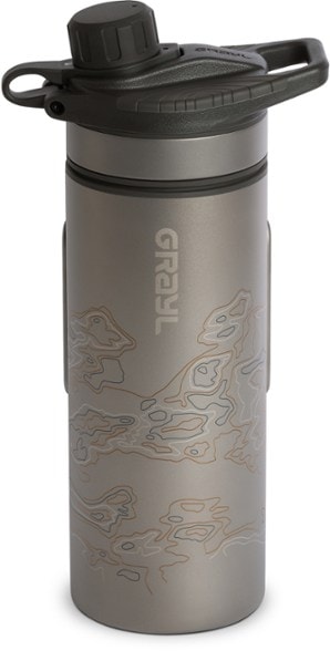 Grayl GeoPress Ti titanium water purifier bottle with a scenic mountain backdrop.