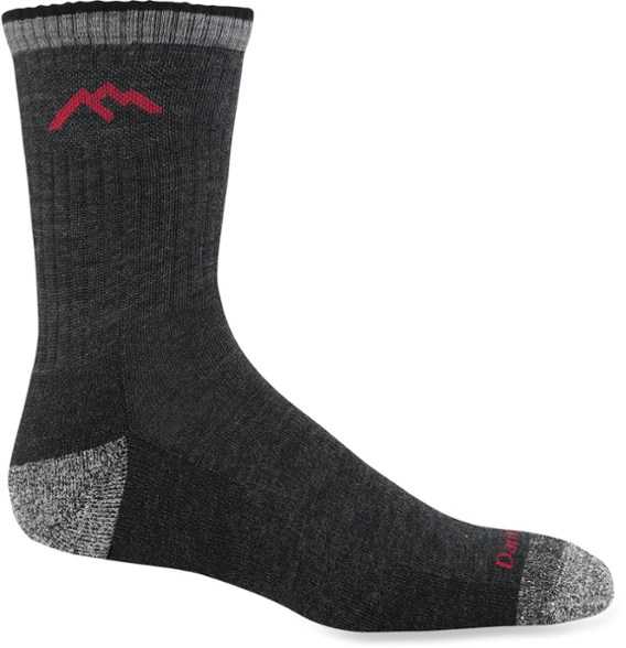 Darn Tough men's cushioned crew hiking socks displayed outdoors, showcasing their durability and comfort.