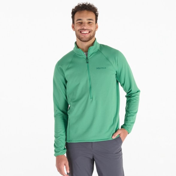 Man wearing a technical fleece half-zip pullover while hiking in winter.