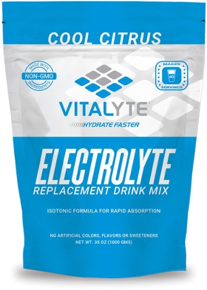 Vitalyte electrolyte drink mix powder in a scoop surrounded by fresh fruits.