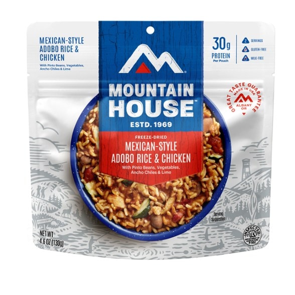 Front view of the gluten-free adobo chicken rice pouch set on a camping table beside a stove