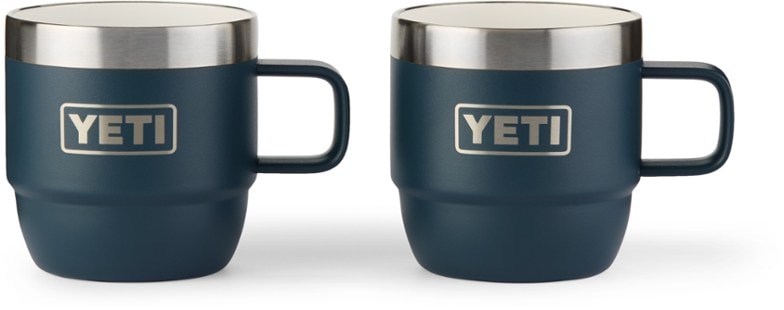 Two YETI DuraSip™ stackable mugs side-by-side on a weathered picnic table