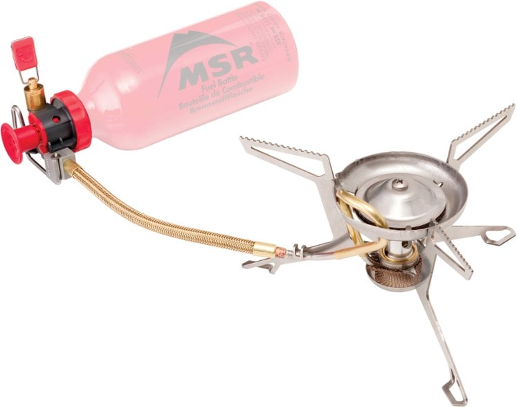 Traveler's Choice Multi-Fuel Backpacking Stove set up in the wilderness with a pot boiling water.