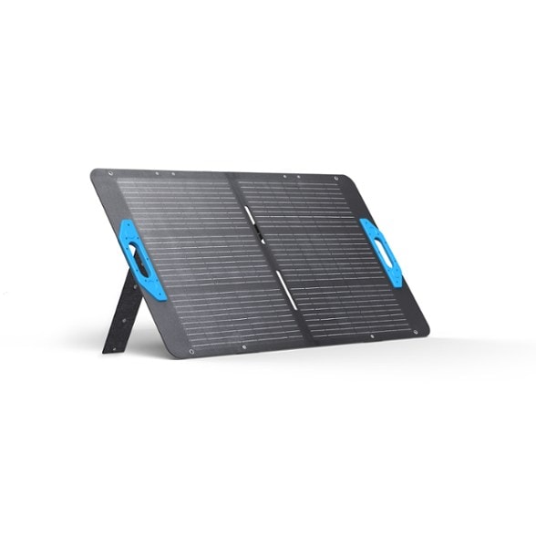 Close-up of the TrailCharge portable solar panel unfolded on grass, capturing midday sunlight.