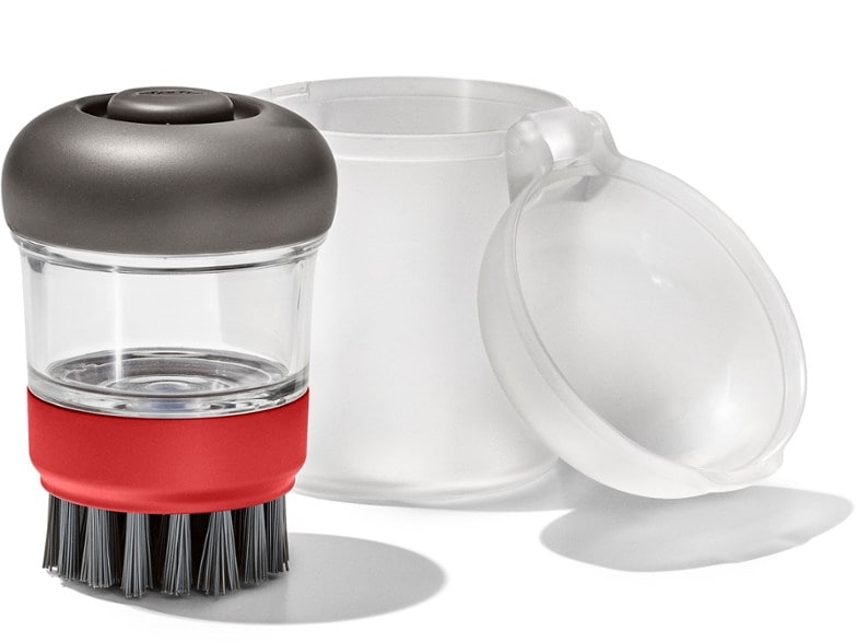 Close-up of the soap dispensing brush resting in its leakproof travel case—perfect for camping cleanup.