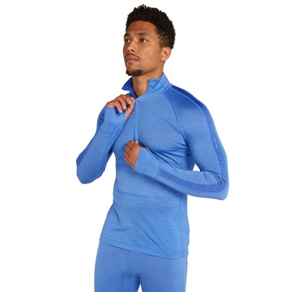 Men's Icebreaker merino half-zip top in action while skiing, showcasing breathability.