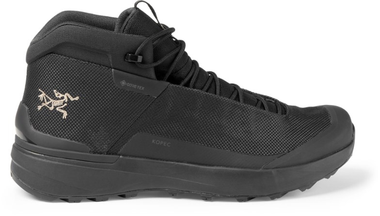 Side view of Arc'teryx Kopec Mid GTX hiking boots on rocky ground.