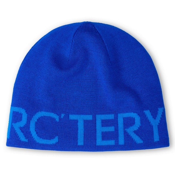 Arc'teryx reversible beanie showing the branded side in snowy mountain setting, ideal winter hat for hiking