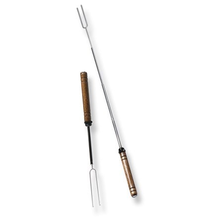 Pair of roasting forks extended over campfire with marshmallows on tips