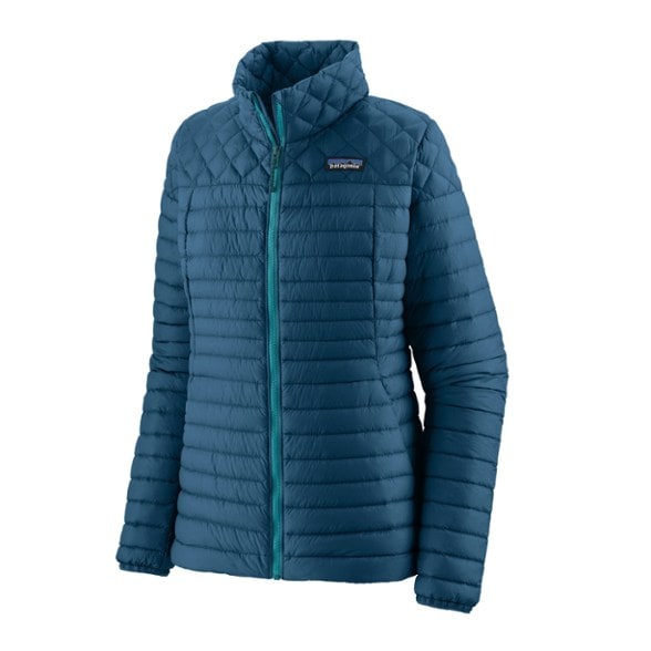 Front view of women's down jacket worn during a mountain hike—featuring lightweight build and contoured fit.