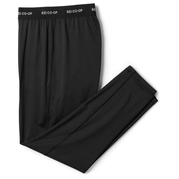 Men's lightweight base layer pants in action during a mountain hike, showcasing the moisture-wicking fabric.
