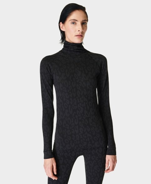 Front view of women's high-neck thermal base layer top for skiing, showcasing thumbholes and sleek design.