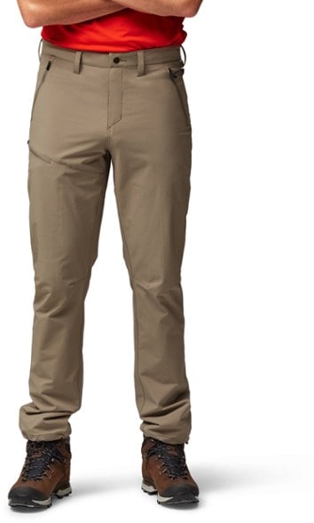 Front view of men's stretch hiking trousers with zippered pockets on a rocky trail