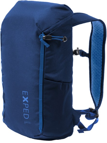 Exped Summit 15 backpack in a scenic mountain trail, showcasing its lightweight design and hydration system outlet.