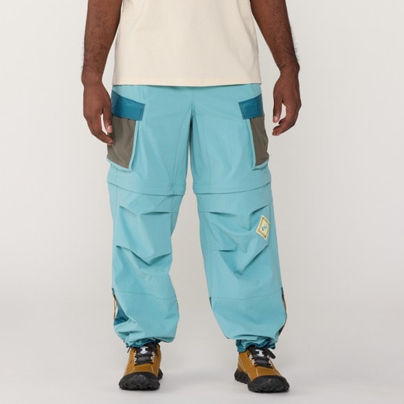 Front view of Half Dome Adventure Zip-Off Pants on a rocky trail, highlighting their stylish design.