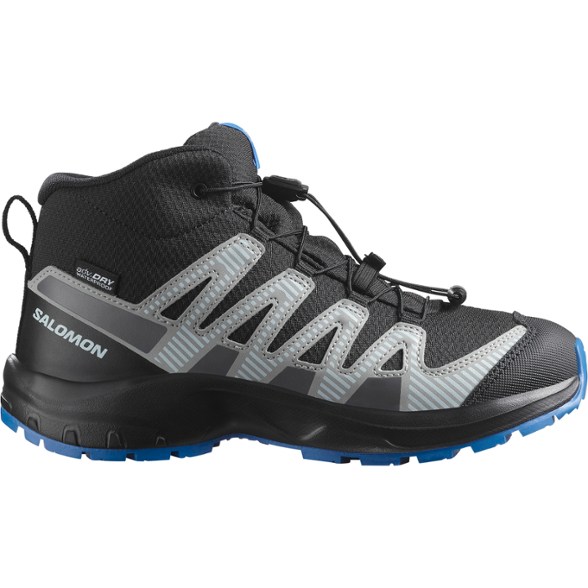 Salomon XA Pro V8 Mid Kids' Waterproof Hiking Boots from the side, showcasing the protective toe cap and gusseted tongue.
