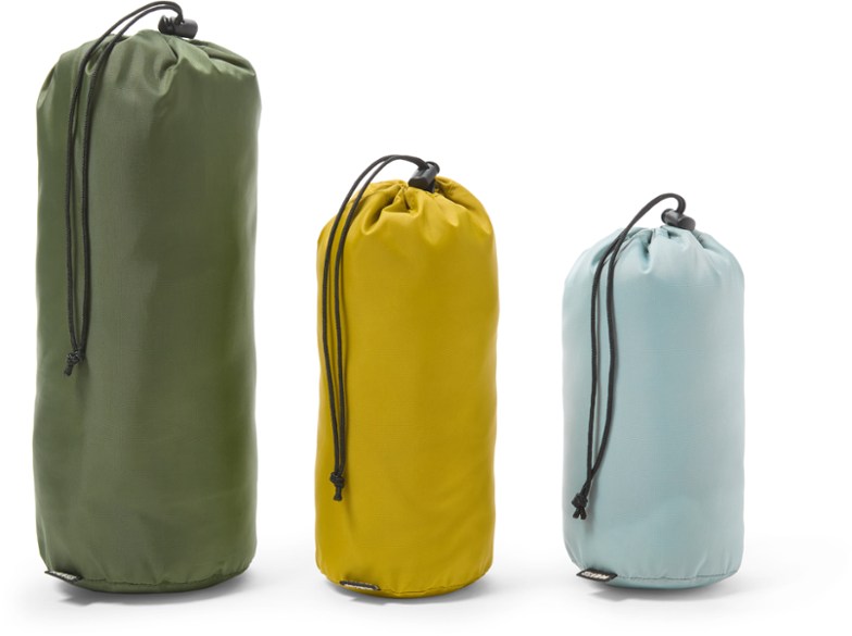 Color-coded ditty sacks in various sizes for camping organization, displayed outdoors.