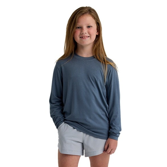 Front view of a child in the SunShield Long Sleeve Kids Shirt with Thumbholes, exploring the park.